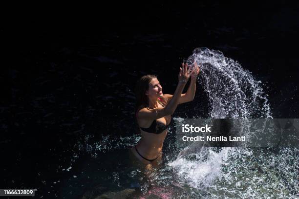 Woman Splashing Sea Water Stock Photo - Download Image Now - Adult, Beach, Beach Holiday