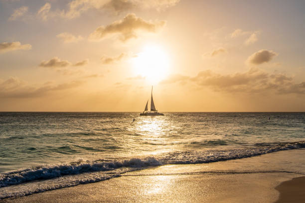 tramonto caraibico, aruba - sailing sailboat sunset aruba foto e immagini stock