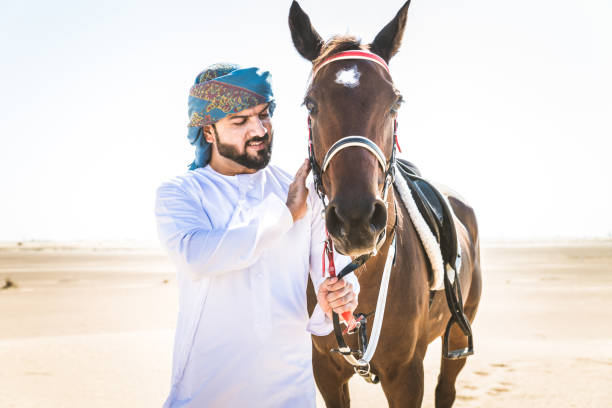 istock Arabian man with horse in the desert 1166635169
