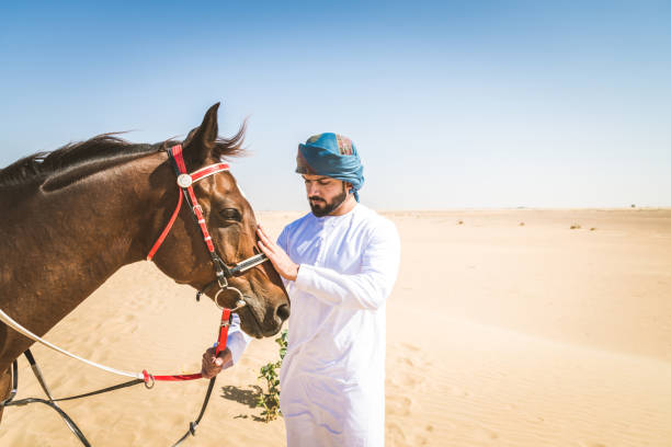 istock Arabian man with horse in the desert 1166635256