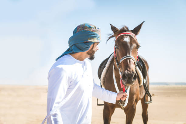 istock Arabian man with horse in the desert 1166635338