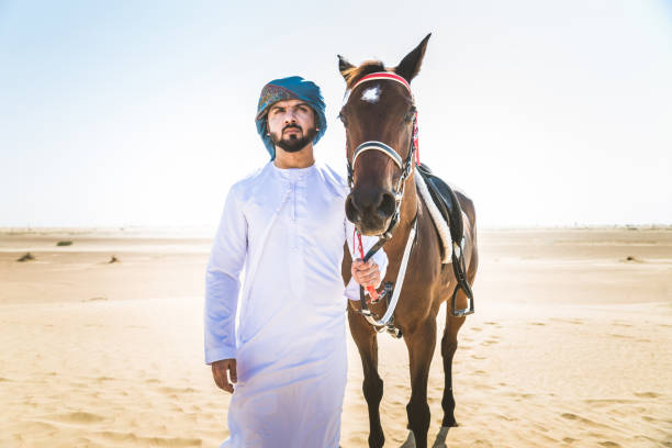 istock Arabian man with horse in the desert 1166635952