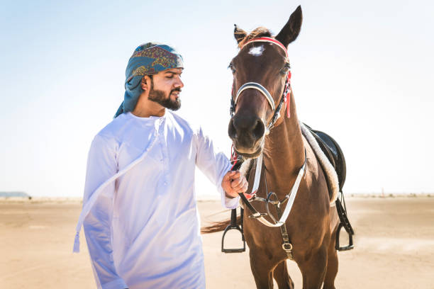 istock Arabian man with horse in the desert 1166636122
