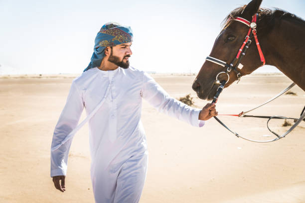 istock Arabian man with horse in the desert 1166636124