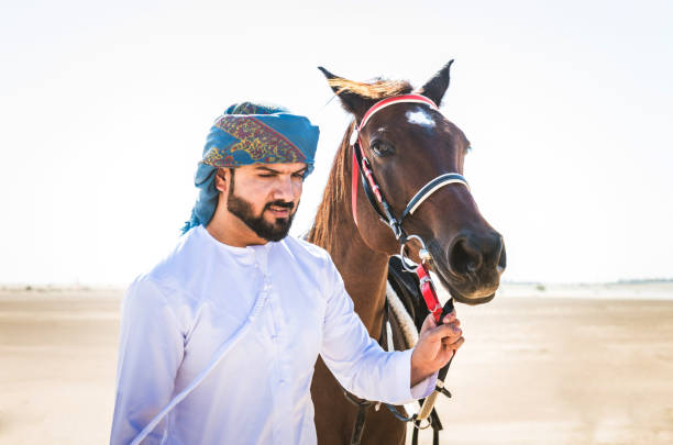 istock Arabian man with horse in the desert 1166636135