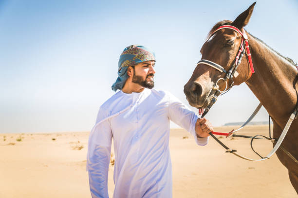 istock Arabian man with horse in the desert 1166636200