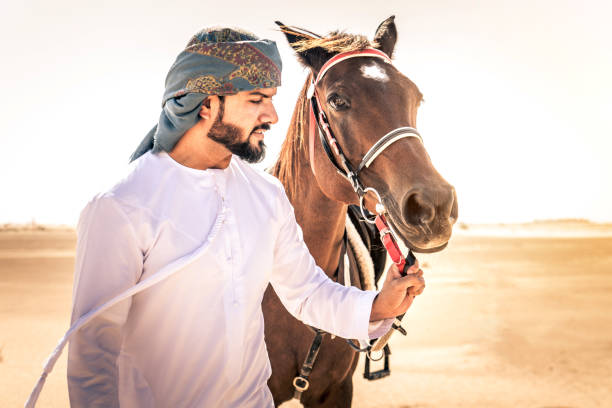 istock Arabian man with horse in the desert 1166636269