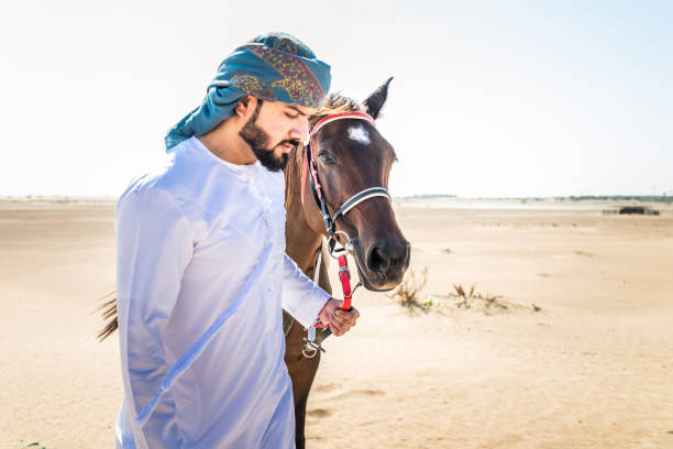 istock Arabian man with horse in the desert 1166636305