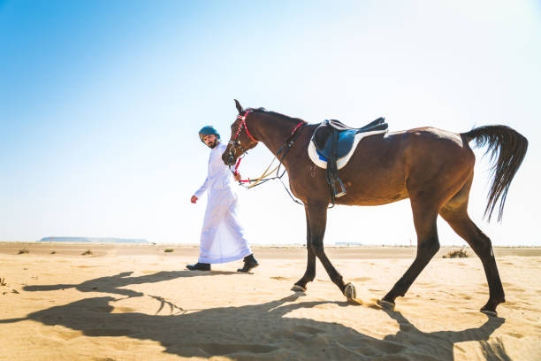 istock Arabian man with horse in the desert 1166636405
