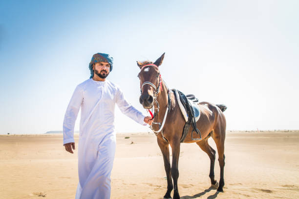 istock Arabian man with horse in the desert 1166636534