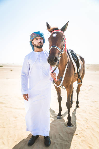 istock Arabian man with horse in the desert 1166636552