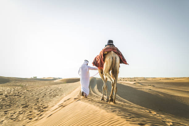 istock Arabian man with camel in the desert 1166639644