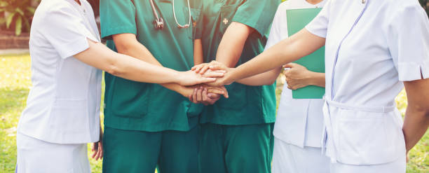 istock hands together between the doctor and nurses 1166639698