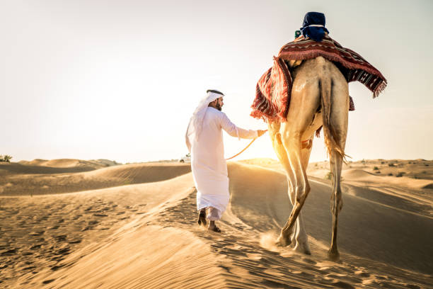 istock Arabian man with camel in the desert 1166640383