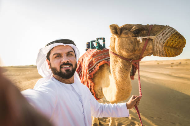 砂漠でラクダを持つアラビア人 - united arab emirates middle eastern ethnicity men camel ストックフォトと画像