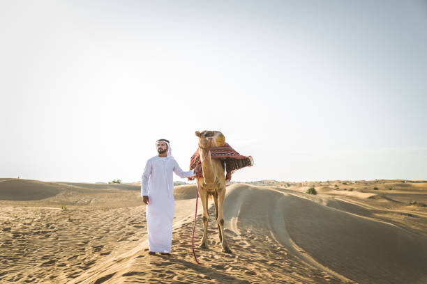 istock Arabian man with camel in the desert 1166640561