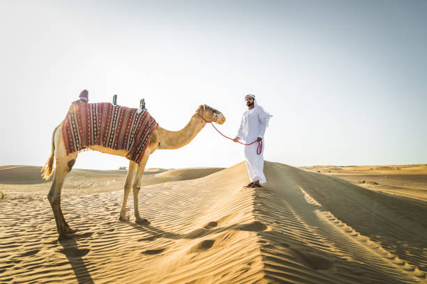 istock Arabian man with camel in the desert 1166640589