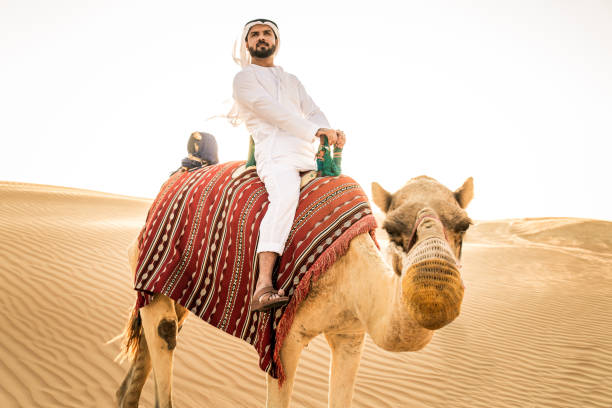 砂漠��でラクダを持つアラビア人 - united arab emirates middle eastern ethnicity men camel ストックフォトと画像
