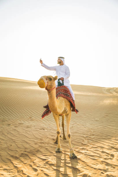 istock Arabian man with camel in the desert 1166641100