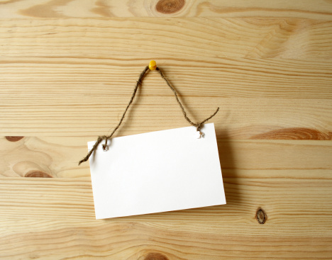 White paper noteboard for notes hanging with rope on wooden background