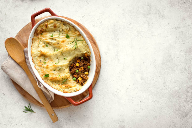 Shepherd's Pie Shepherd's Pie with ground beef, potato and cheese on white background, top view, copy space. Traditional homemade casserole - Shepherds Pie. savory pie stock pictures, royalty-free photos & images