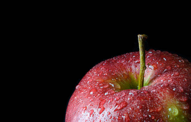 istock Red wet apple in black background 1166642638