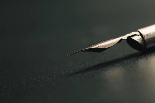 istock Old fountain pen on a black textured background 1166643758