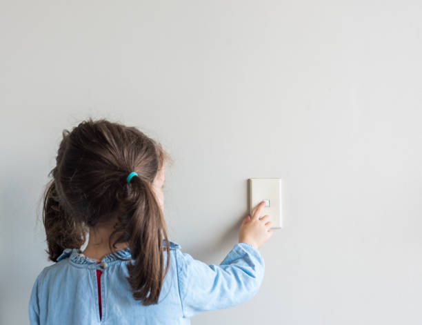 istock Rear View Of Girl Touching Switch Light On Wall 1166647761