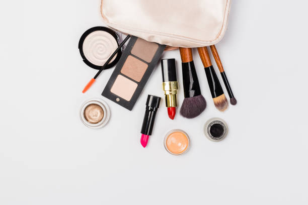 istock Makeup products with cosmetic bag and macaroons on light background 1166648082