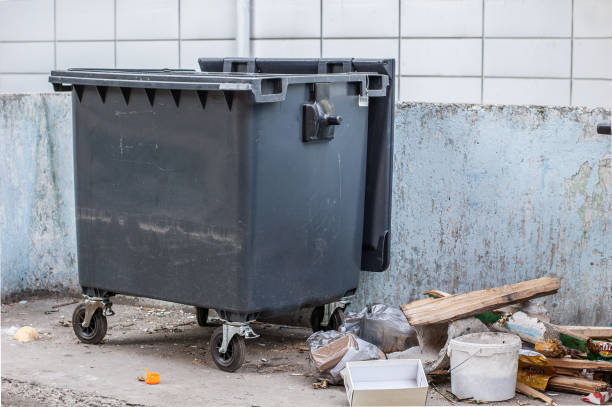 istock Dumpster on the grey wall background. Garbage bin near housing 1166649599