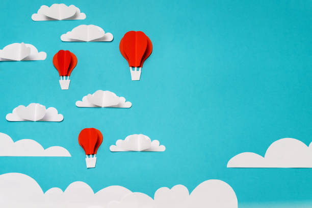 istock Paper cut objects composition with hot air balloons, clouds, and sun. Creative concept for banner/landing/background designs. 1166649978