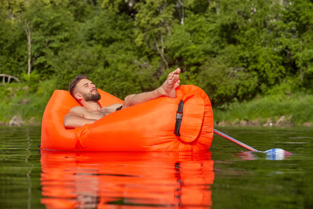 istock Young man floats on an air sofa. 1166650583