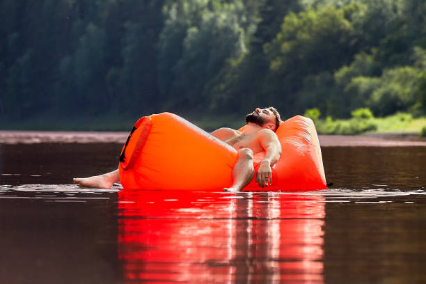 istock Young man floats on an inflatable lounge. 1166650594