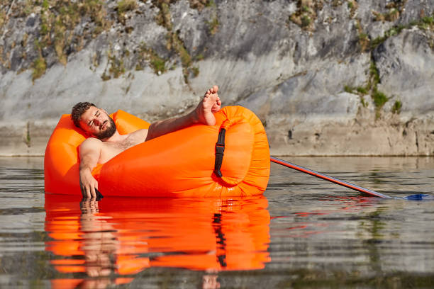 istock Businessman is sleeping in a floating lounger. 1166650608