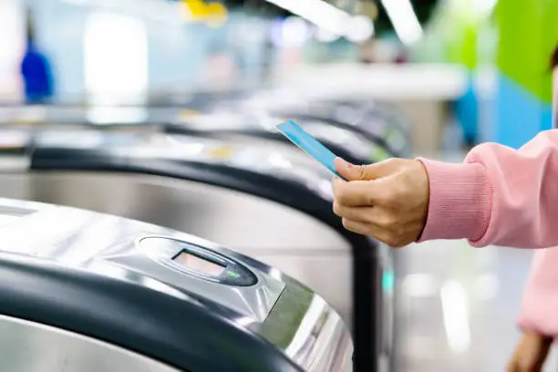 Photo of Woman hand scanning train ticket to subway entrance gate. Transportation concept