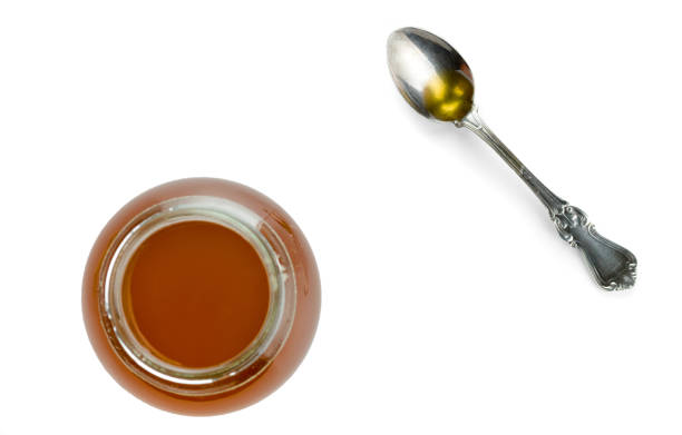 istock Round glass jar and spoon with freshly prepared ghee isolated on white background. 1166653227