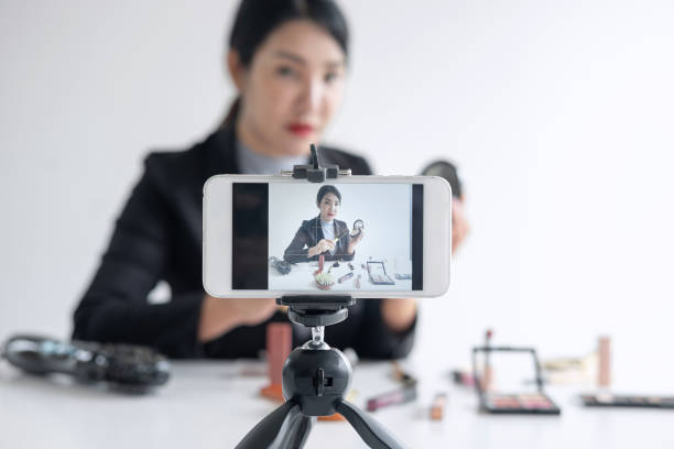 istock Female Vlogger With Beauty Products Seen On Mobile Screen Over White Background 1166654949