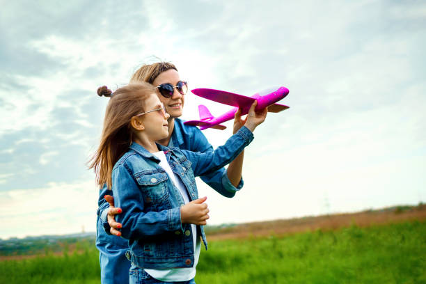 istock Mother and daughter playing with toy plane 1166658271