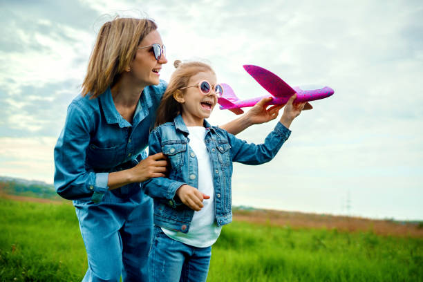 istock Mother and daughter playing with toy plane 1166658303