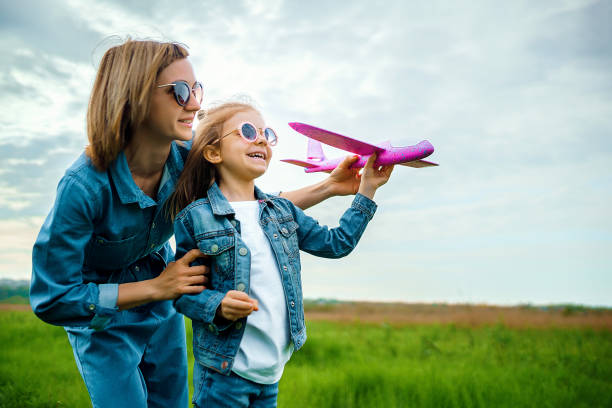 istock Mother and daughter playing with toy plane 1166658312