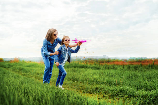 istock Mother and daughter playing with toy plane 1166658332