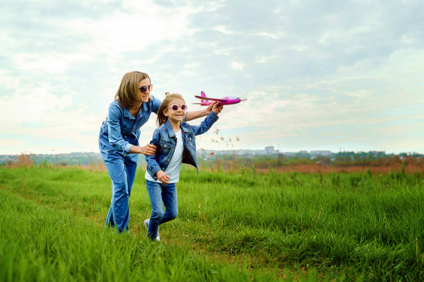 istock Mother and daughter playing with toy plane 1166658337