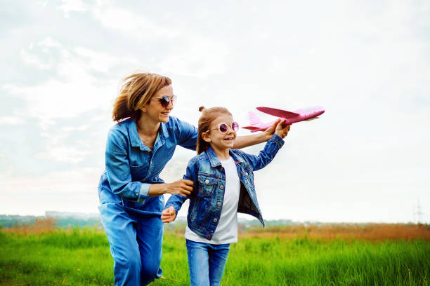 istock Mother and daughter playing with toy plane 1166658347
