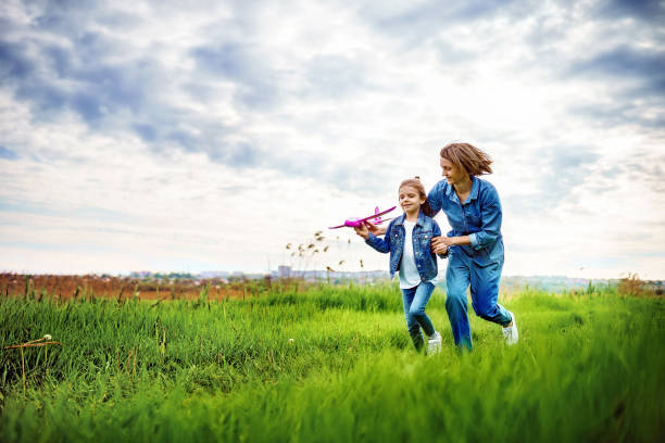 istock Mother and daughter playing with toy plane 1166658434