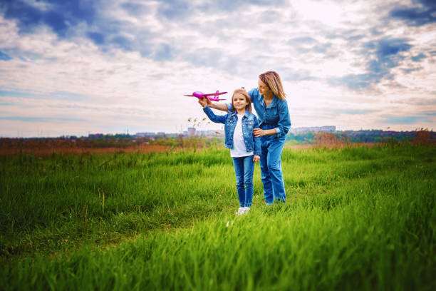 istock Mother and daughter playing with toy plane 1166658440