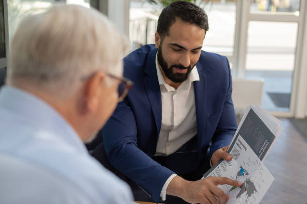 istock Concentrated bearded man pointing at world map 1166663527