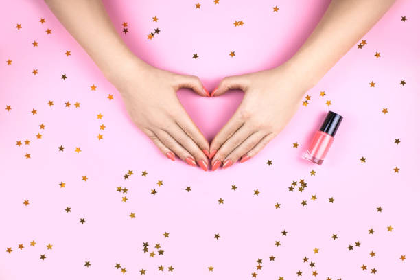 istock Woman's hand with Coral manicure making heart. 1166663609