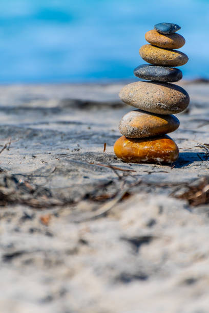istock Stacked stones/ pebbles naturally balanced on a sunny summer day by the beach. Rock Zen stack balancing. 1166665160