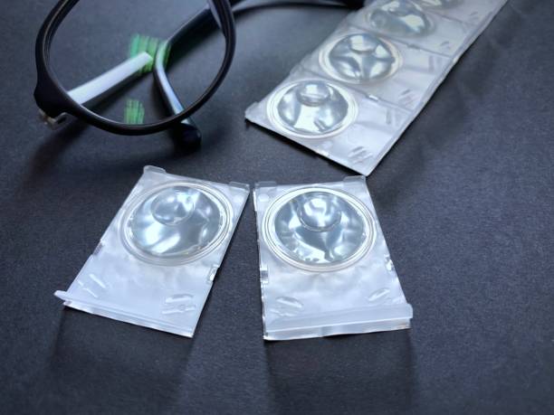 istock contact lens blisters and glasses on a dark background. 1166666146