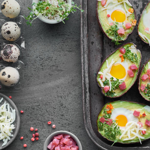 istock Keto diet dish: Avocado boats with ham cubes, quail eggs, cheese on dark with copy-space 1166666314